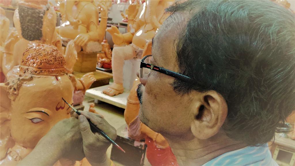 Eyes are painted just two days prior to the festival Painting in progress. Ganapathi idols in clay
